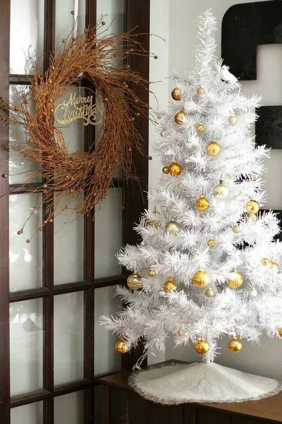 a white Christmas tree decorated with gold ornaments is a glam and chic idea for a Christmas space with gold touches