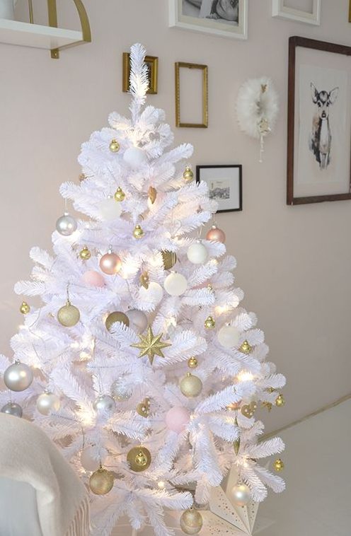 a white Christmas tree decorated with gold, pink and silver ornaments and lights is a very cool and chic idea