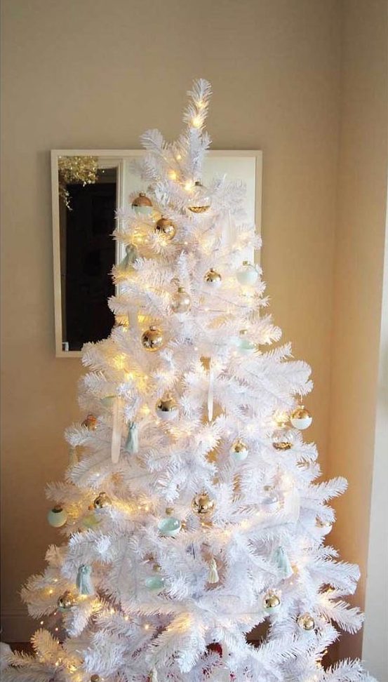 a white Christmas tree decorated with gold, white and mint ornaments and lights looks very fresh and cool