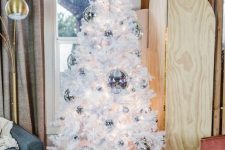 a white Christmas tree decorated with silver disco balls is a lovely decor idea not only for Christmas but also for NYE