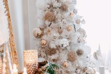 a white Christmas tree styled with silver and gold ornaments, usual and oversized ones