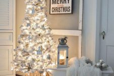 a white Christmas tree with lights, white ornaments and houses is a cool and catchy solution