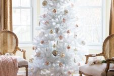 a white Christmas tree with pink and gold ornaments, baubles and stars, is a catchy idea