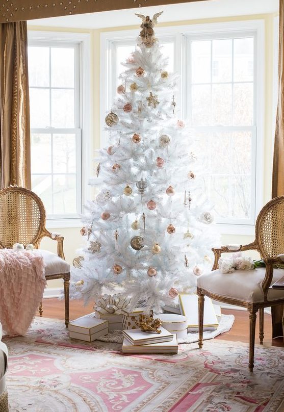 a white Christmas tree with pink and gold ornaments, baubles and stars, is a catchy idea