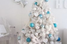 a white tree with white ornaments and some bold turquoise and blue ones to make it stand out