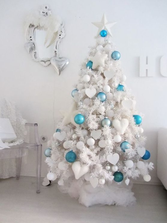 a white tree with white ornaments and some bold turquoise and blue ones to make it stand out