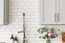 an elegant dove grey kitchen with white marble countertops and a white subway tile backsplash for an airy feel
