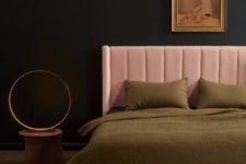 a refined moody bedroom with black walls, a pink upholstered bed and olive green bedding, a nightstand with lights and a blush pink rug is a cool and lovely space