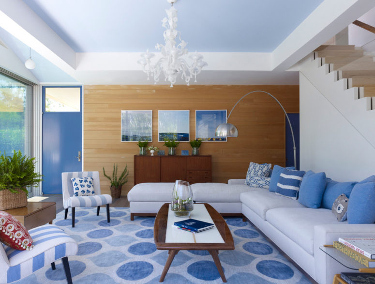 This contemporary coastal-inspired room features amazing dark brown wood furniture and lots of blue accents in different shades and patters. (Austin Patterson Disston Architects)