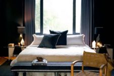 a chic moody bedroom with an art deco twist and geometric and gold details, a black pendant lamp and a black hairpin bench