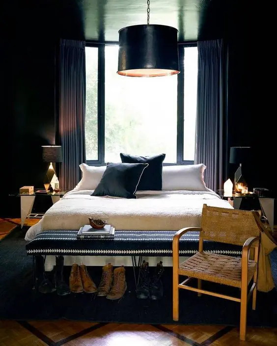 a chic moody bedroom with an art deco twist and geometric and gold details, a black pendant lamp and a black hairpin bench