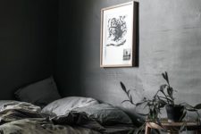 an elegant grey moody bedroom with a tiered glass nightstand, potted plants, grey bedding and peaceful light