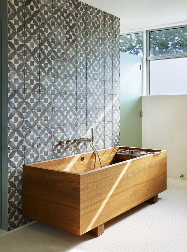 a striking full-size wooden bathtub looks great against a geometric accent wall (Abramson Teiger Architects)