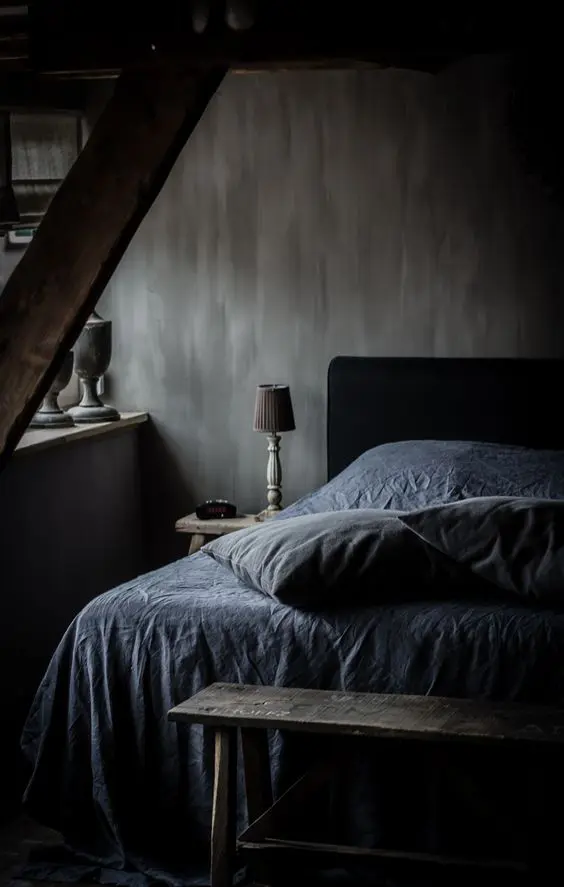 a moody bedroom with textural walls and vintage finds from a flea market, a black bed with monochromatic bedding