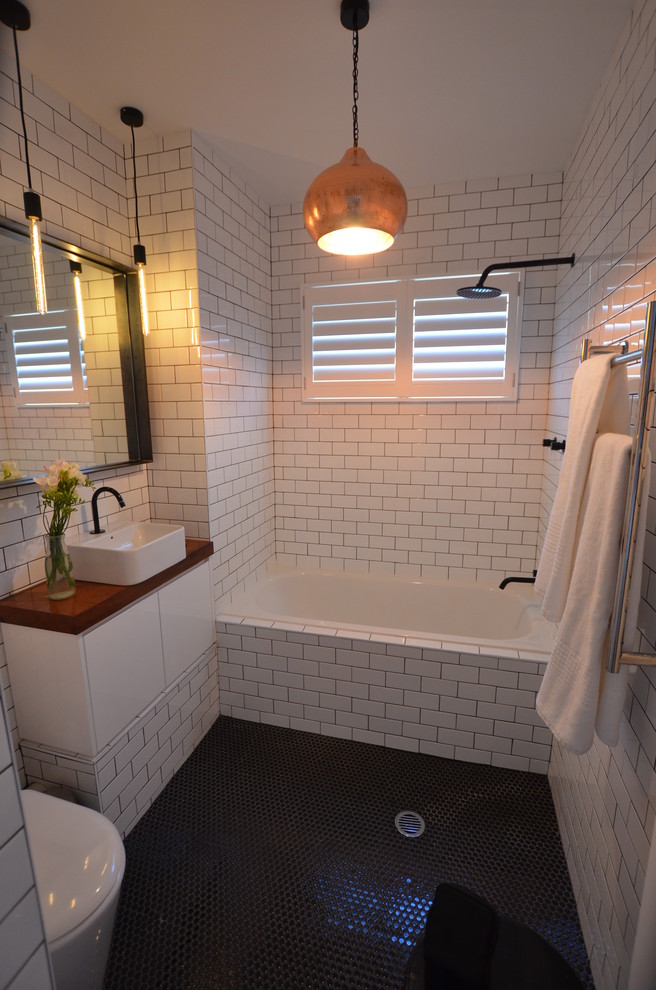 a bathroom with pure place penny tiles on a floor and pure white subway tiles on walls (AN Builders Pty Ltd)