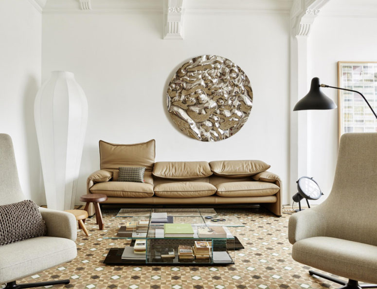 The living room is a spacious and airy room that incorporated comfy ivory and beige furnishings and mosaic tile floors