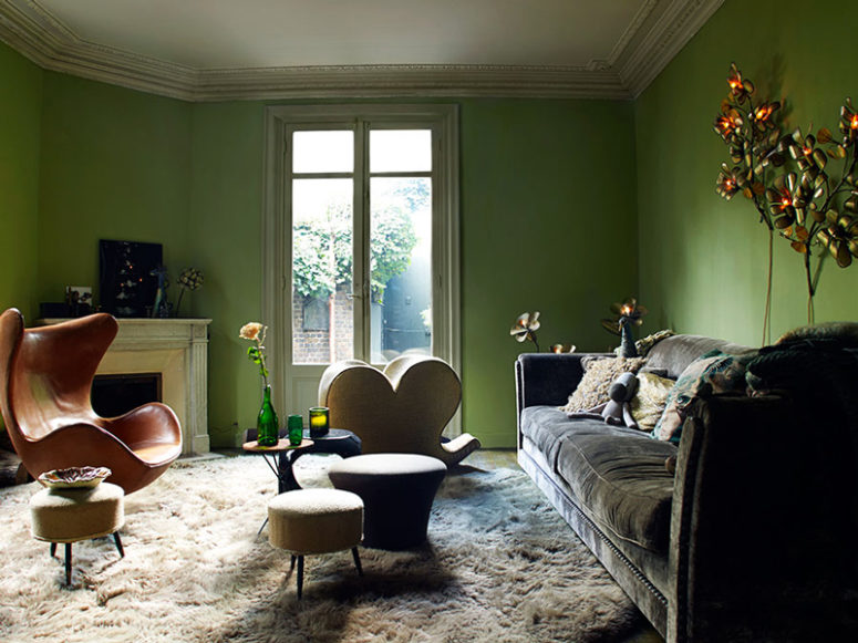 The living room is done in green, there are flower and leaf-shaped lamps, faux fur and velvet, bold chairs