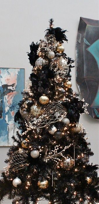 A black Christmas tree decorated in gold and silver for a chic gothic inspired look