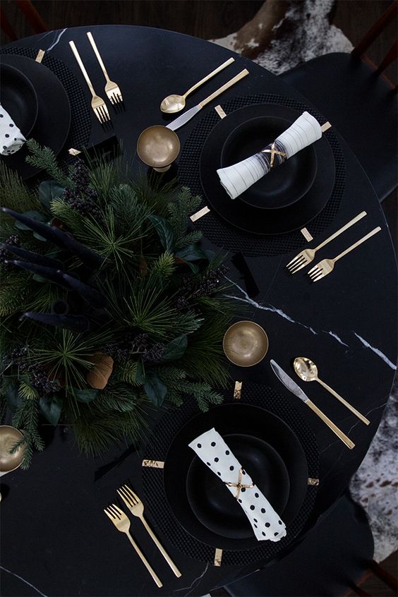 black tablescape with moody evergreens and black candles