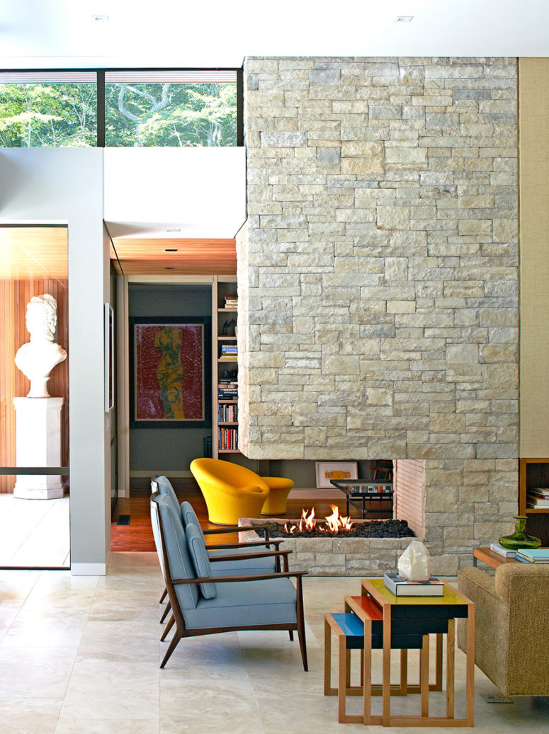The stone-clad fireplace wall divides the living room into two parts