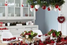 03 a red and white Christmas chandelier, a red table runner and berries for decor