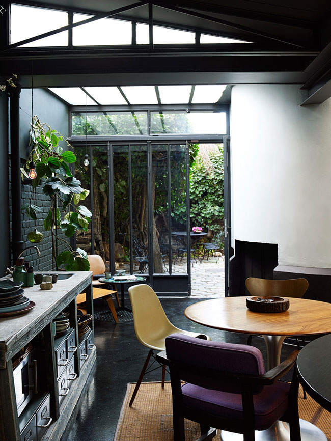 The glazed wall and ceiling fill the house with light, which is essential for a moody kitchen