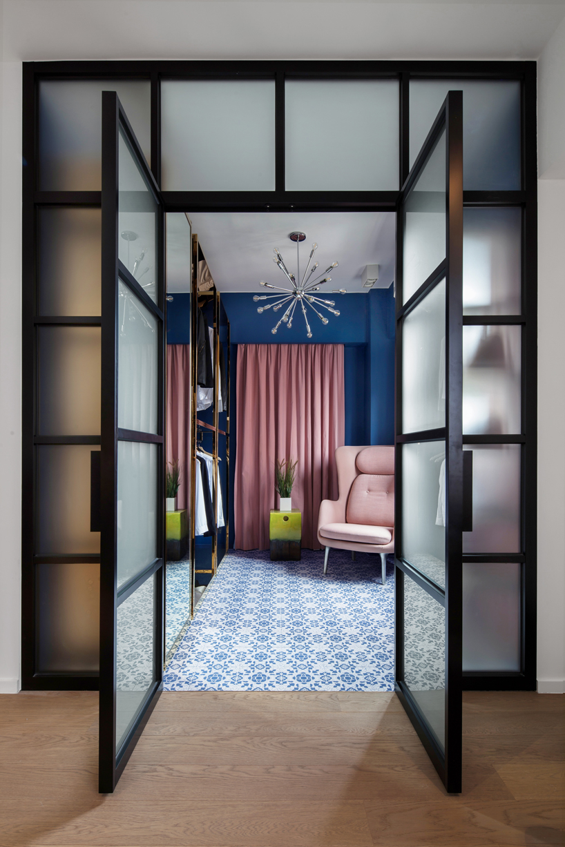 The retail-inspired walk-in wardrobe is complete with custom freestanding polished brass closets