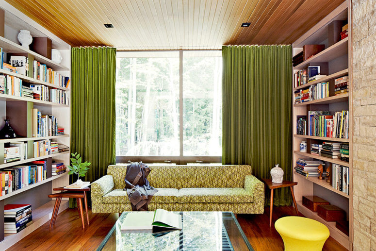The second living room part is a small and cozy library decorated in bold and cheerful colors
