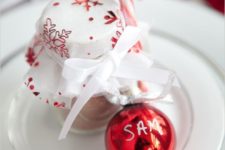04 a red ornament as a place card, a cocoa jar with red and white cloth