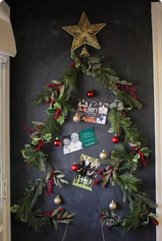 Christmas garland attached to a chalkboard as a tree and cards inside it