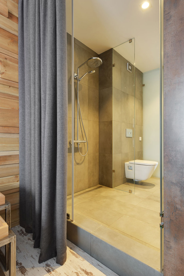 The bathroom has a walk-in shower and is hidden with a curtain from the bedroom to keep it more private