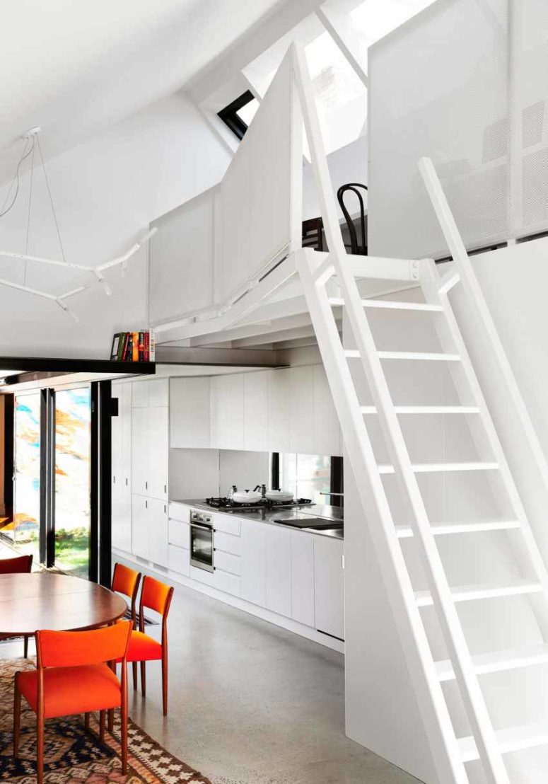 There's a staircase that leads to a small working space above the kitchen