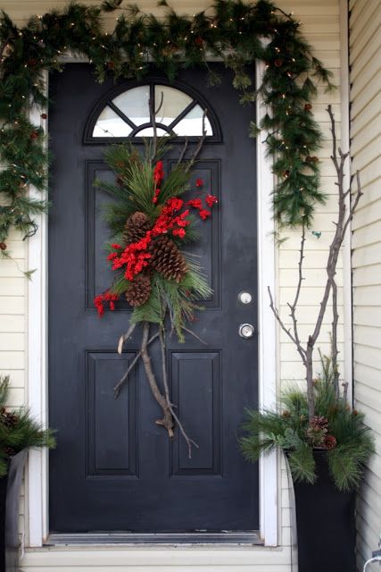 evergreen garland with lights, door decor with pinecones and branches in urns