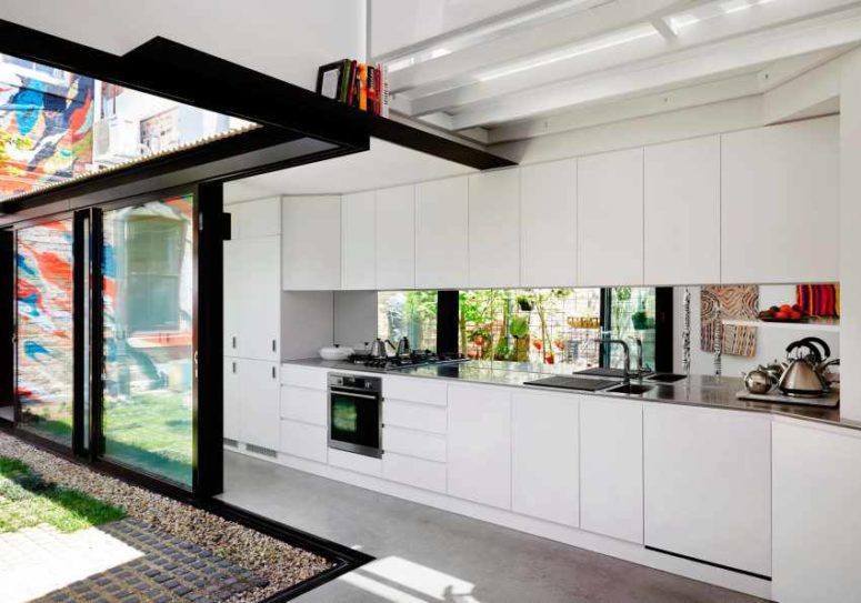 A mirror backsplash reflects the lights and makes the kitchen look more modern
