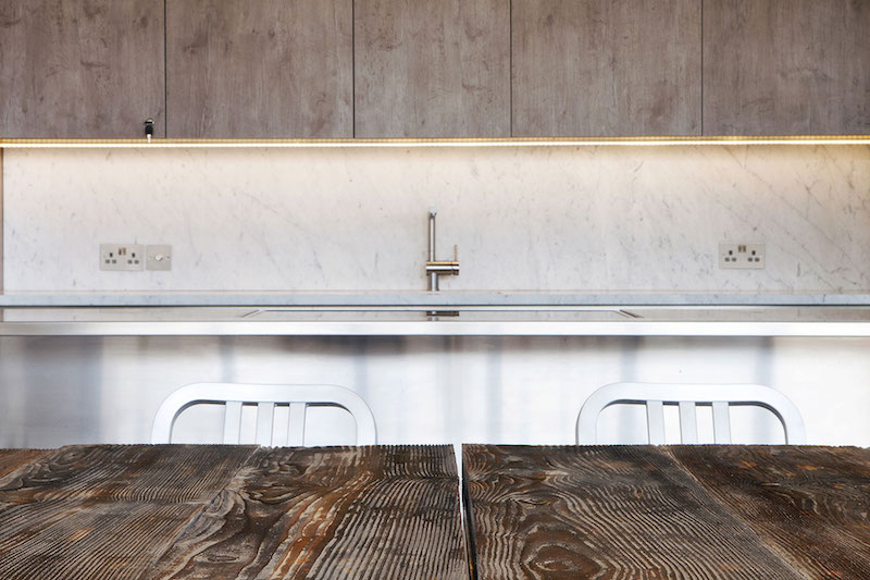 In the kitchen, white marble is combined with natural wood