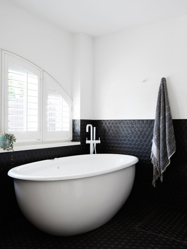 The new ensuite bathroom features charcoal Japanese mosaic tiles, which contrast with white decor