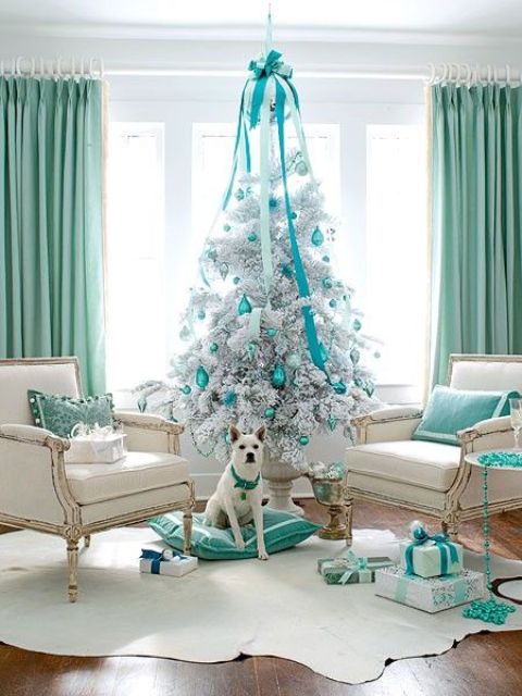 a white Christmas tree with tiffany blue ornaments and a large bow