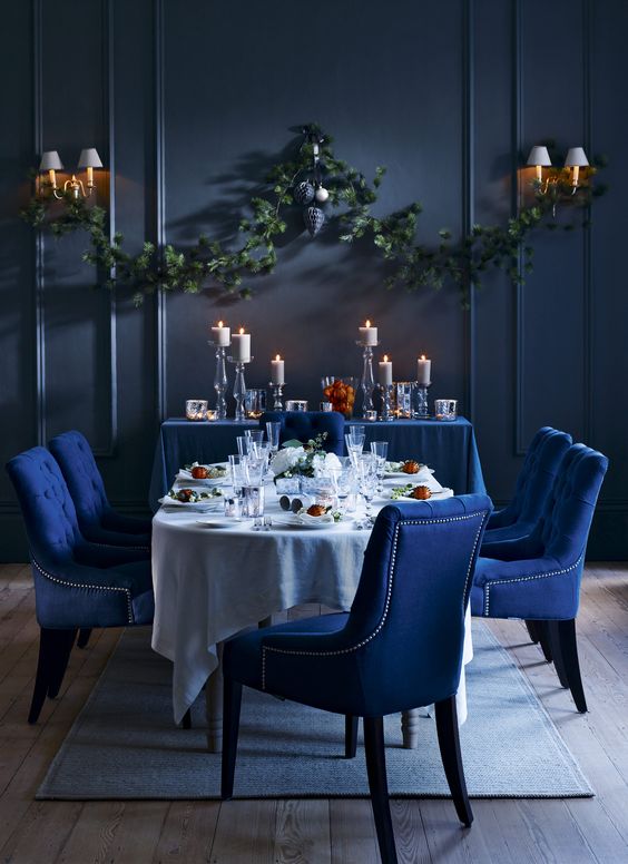 rich colours, moody lighting and shimmering surfaces with dark blue upholstery