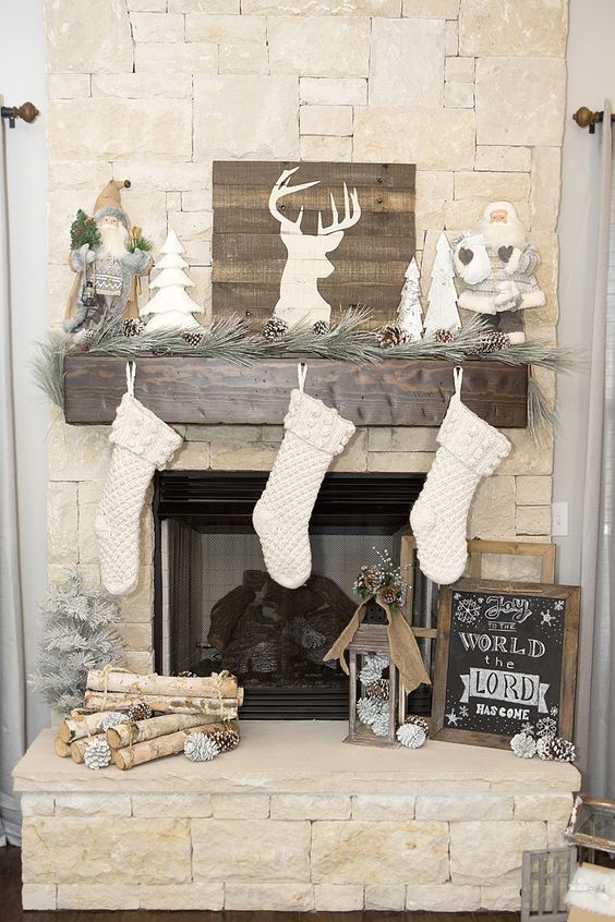rustic mantel with pinecones and wood logs, white stockings and a barnwood sign to refresh the look