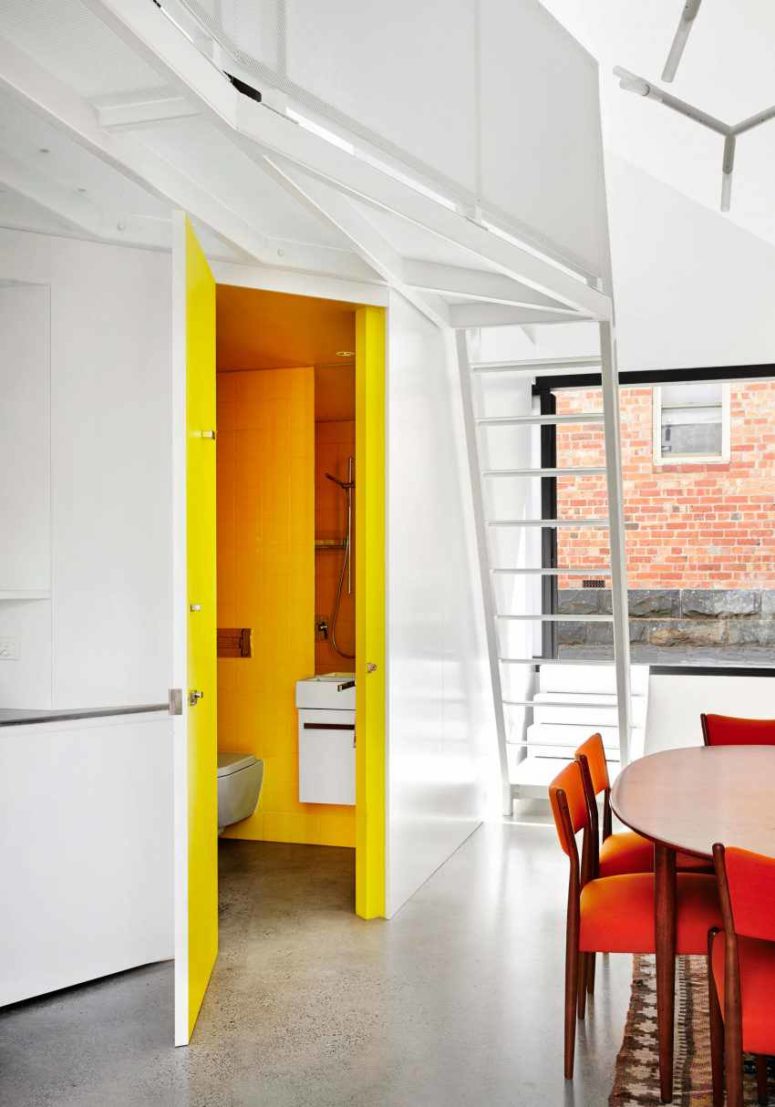 A sunny yellow bathroom is hiding behind one of the kitchen panels