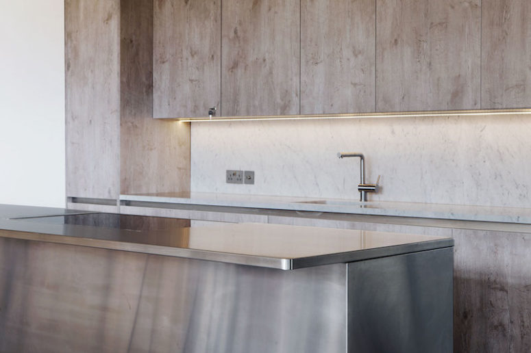 The brushed stainless steel island counter adds a modern touch to the decor