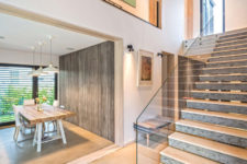 07 The staircase is made of concrete and glass railing for a stylish modern look