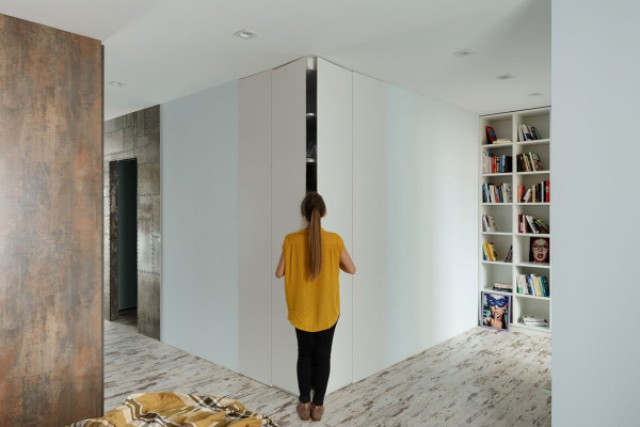 The storage is hidden behind sleek white panels to keep the space decluttered
