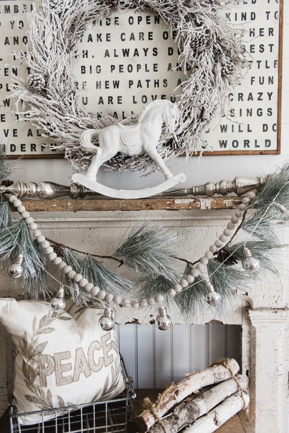 Shabby chic mantel in off white, a snowy wreath, garland and logs
