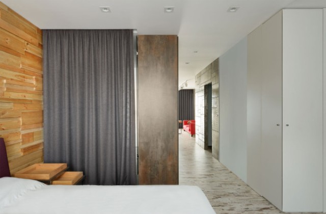 The bedroom features an accent headboard wall made of wood pieces