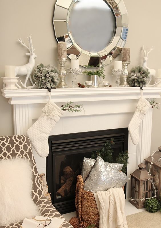 neutral mantel decor with silver candle holders and vases, a deer and flocked fir balls