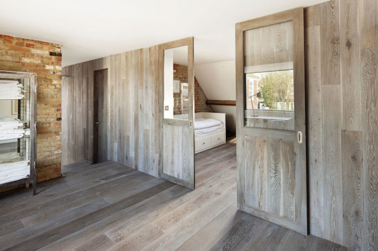 The bedrooms are separated by wooden partitions that match the floor
