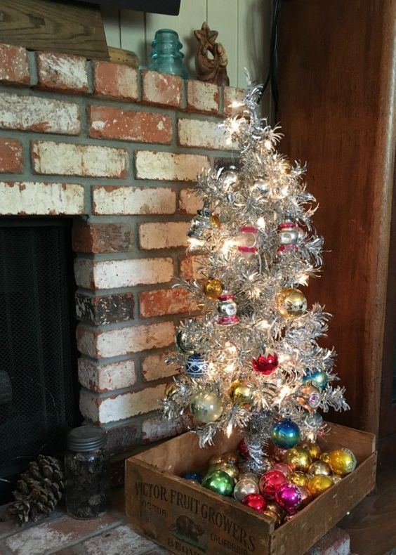 aluminum Christmas tree with bold vintage ornaments and ornaments displayed in the crate