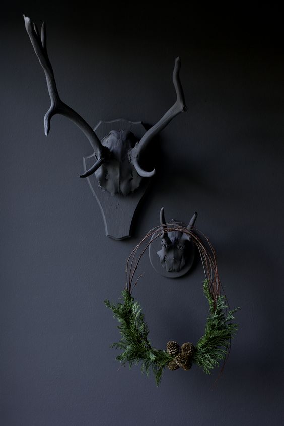 black antlers and a small twig wreath with evergreens and pinecones