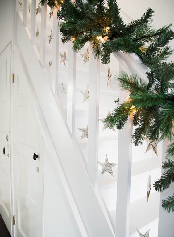 evergreen garland with lights and paper stars hanging